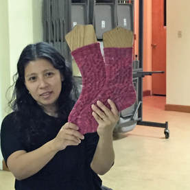 Woman holding up two pink socks on wooden sock blockers